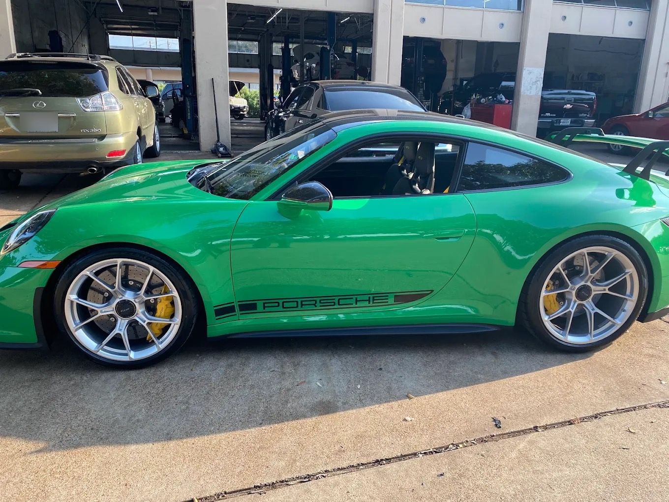 Green Porsche 911 GT3 outside the service bays